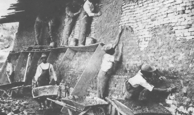 Black and white photo of Black men working on a building