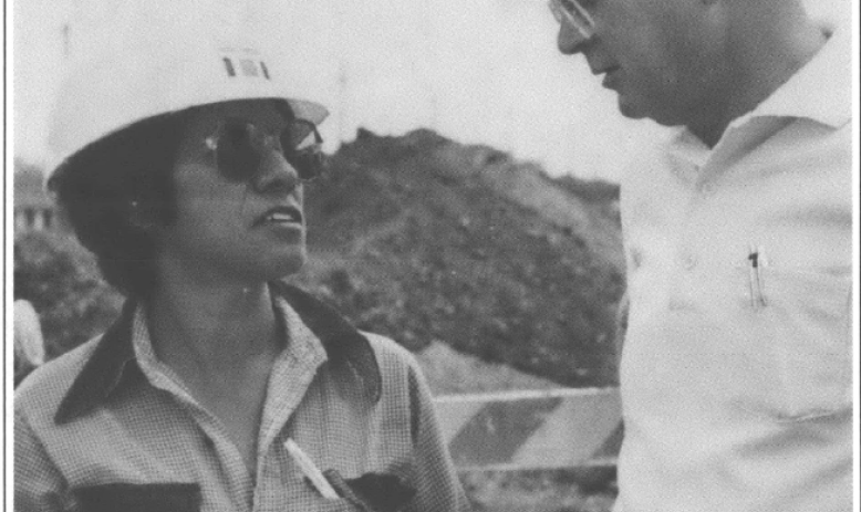a woman and a man in hard hats talking to each other