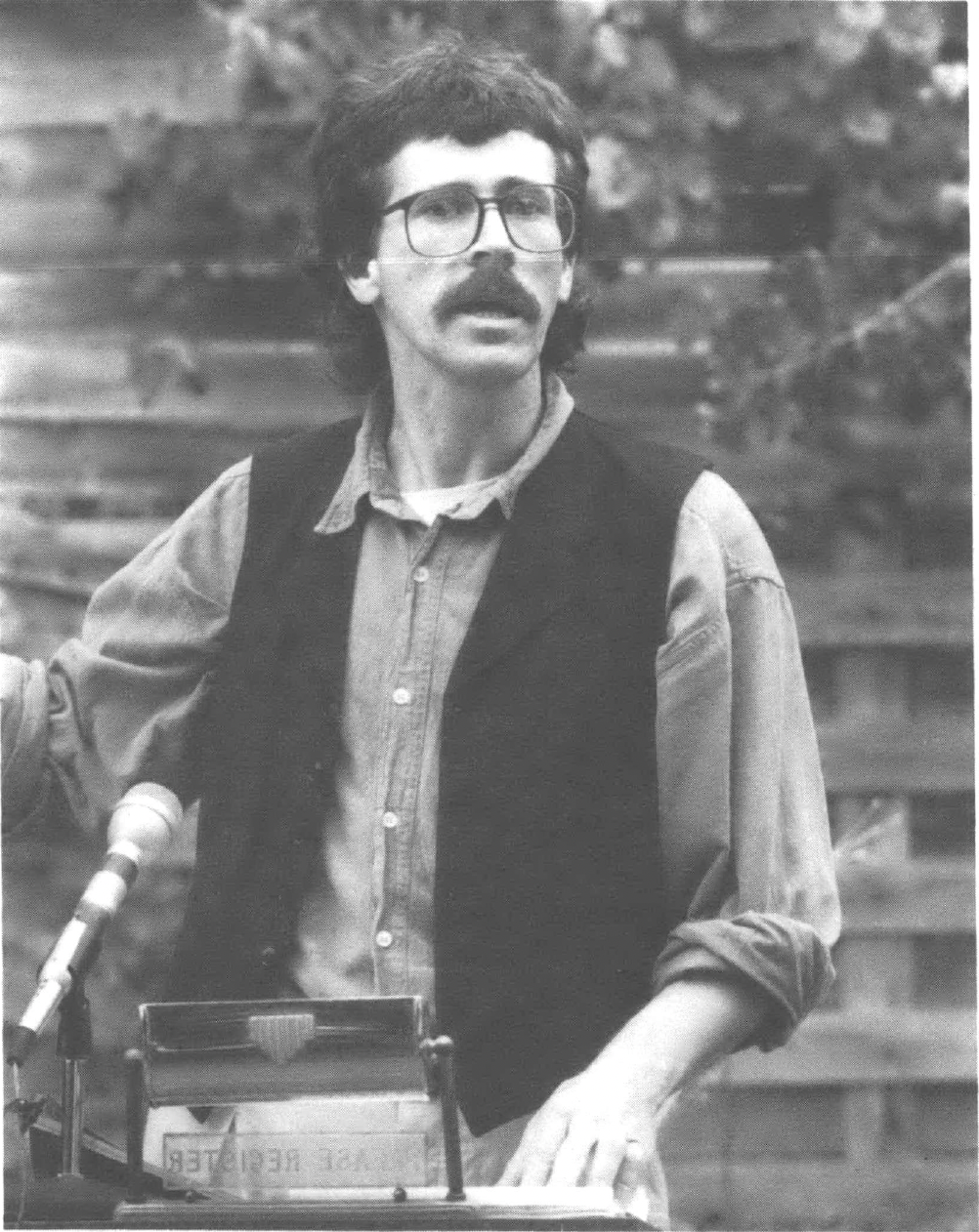 Action shot of man with '70s glasses, hair, and mustache