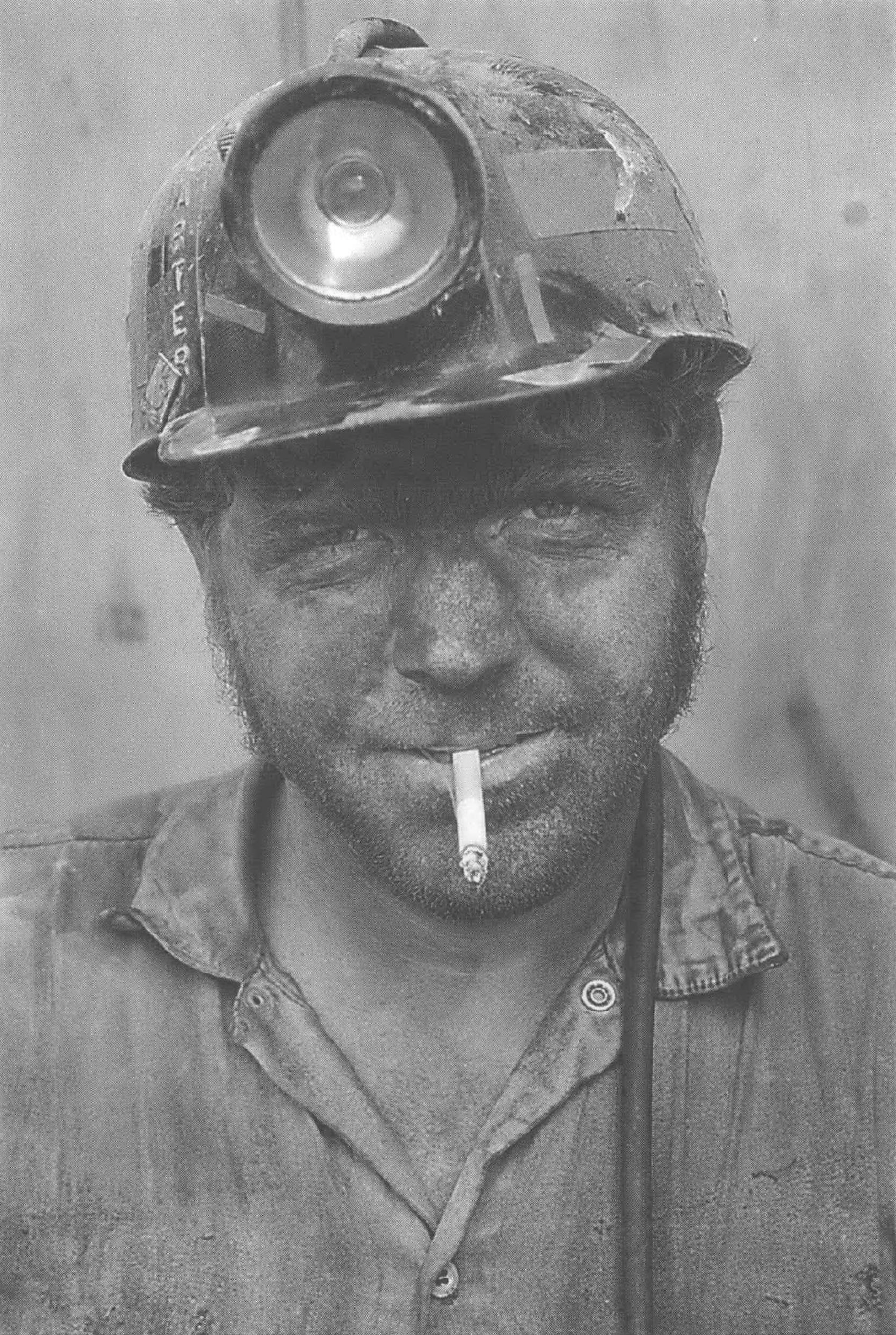 Coal miner in hard hat smoking cigarette