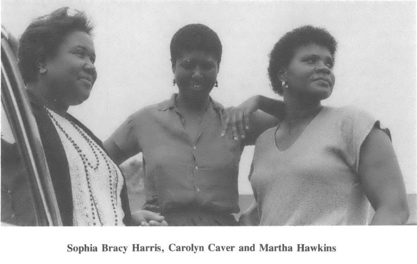 Three Black women embracing and looking off into the distance, identified as Sophia Bracy Harris, Carolyn Caver, and Martha Hawkins
