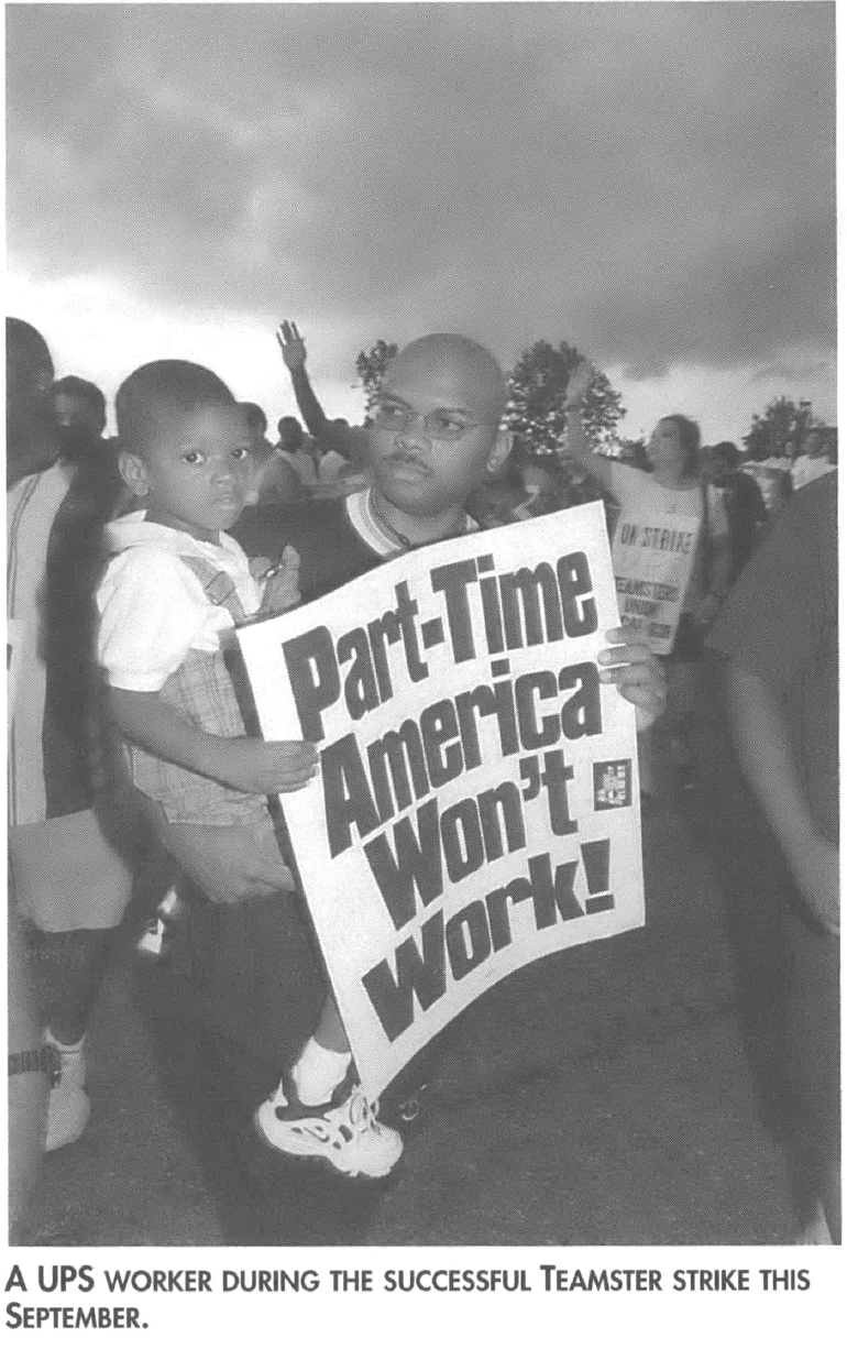 A UPS worker during the successful Teamster strike holding a sign that says "Part-Time America Won't Work!"