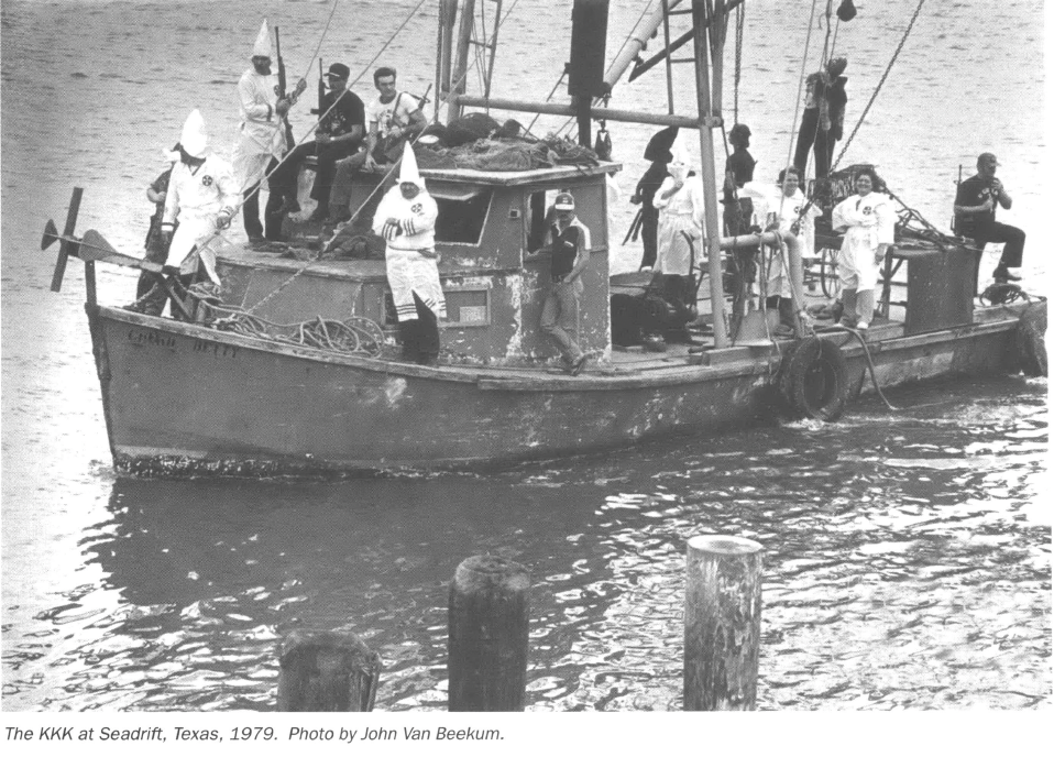 Klan members in Klan robes on a shrimping boat