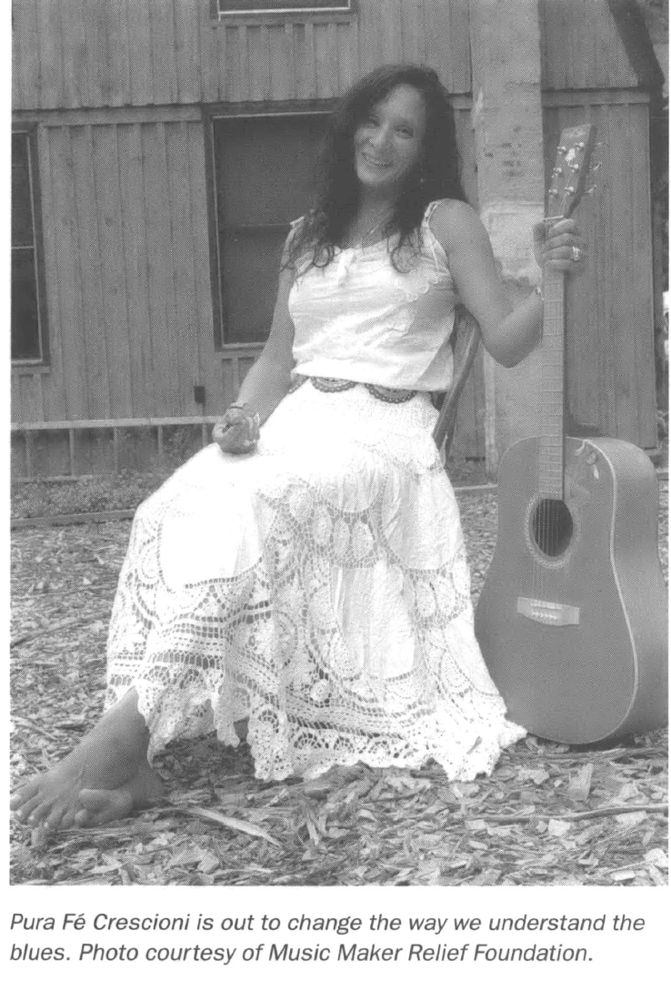 Woman posing with a guitar outside