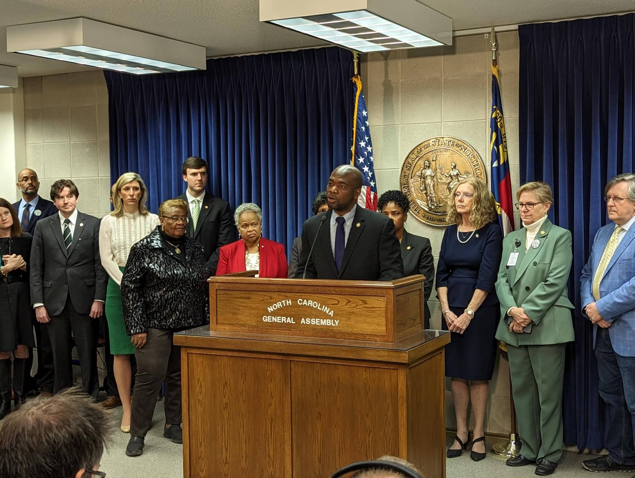 People gathered around a lectern at a press conference